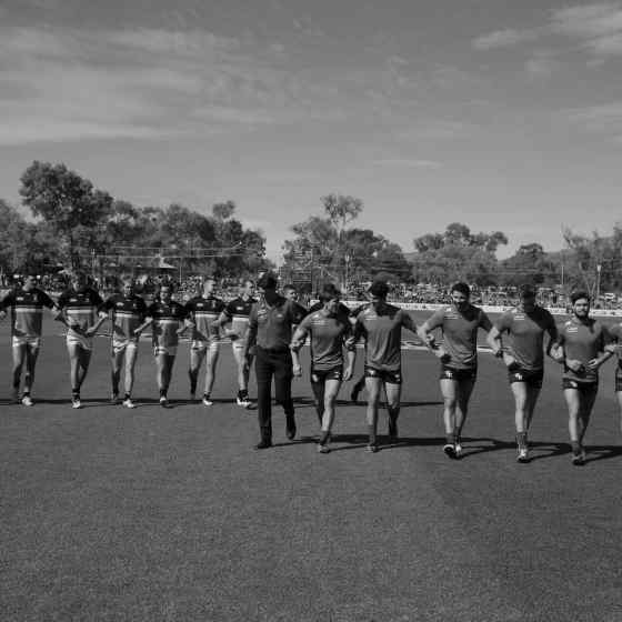 Melbourne and Port Adelaide link arms. Photo Credit: AFL Media