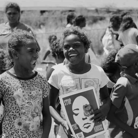 Children hold signs standing up against family violence. 