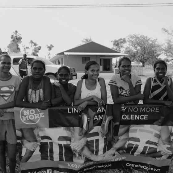 Girls about to play footy at the oval.