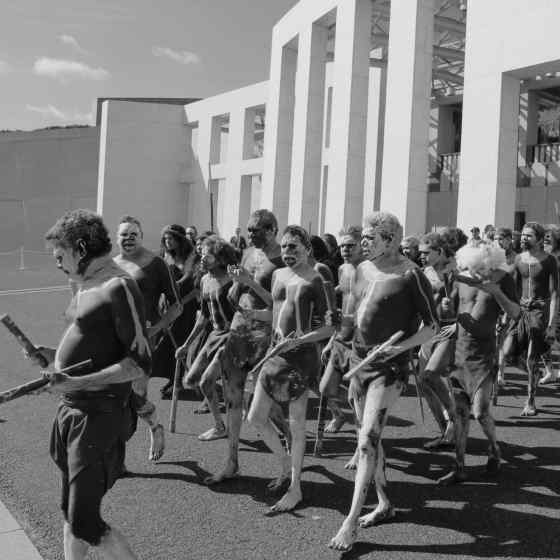 Rirratjingu dancers walking out in front of Parliament House.