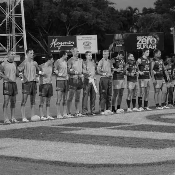 AFLNT umpires and St Marys players link arms before the Grand Final match. 