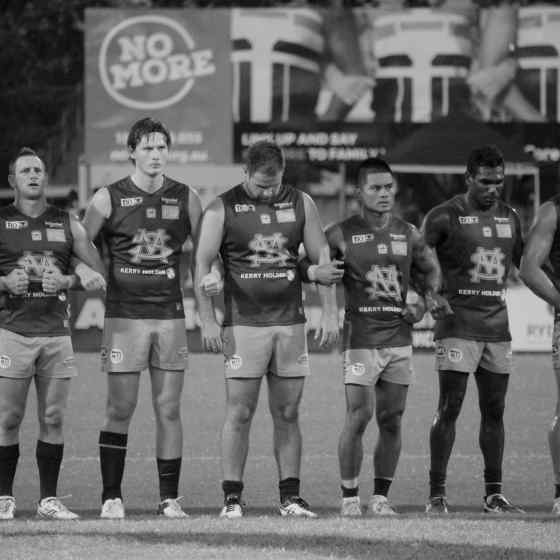 St Marys senior players link up in front of the NO MORE family violence sign at TIO stadium.