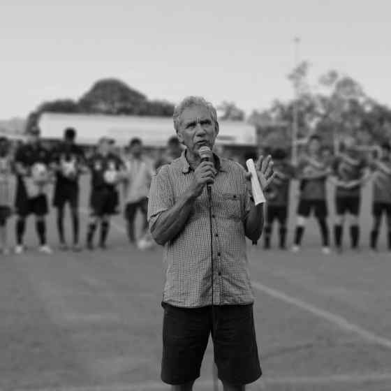 Charlie speaking to the spectators about the meaning behind linking arms.