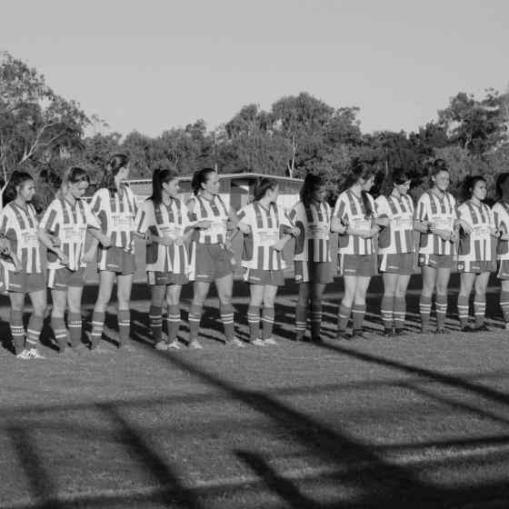 Darwin Olympic women's team link arms before the match. 