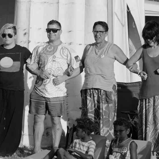 Garma attendees link arms at the bunggul to send a message that they say NO MORE to family violence.