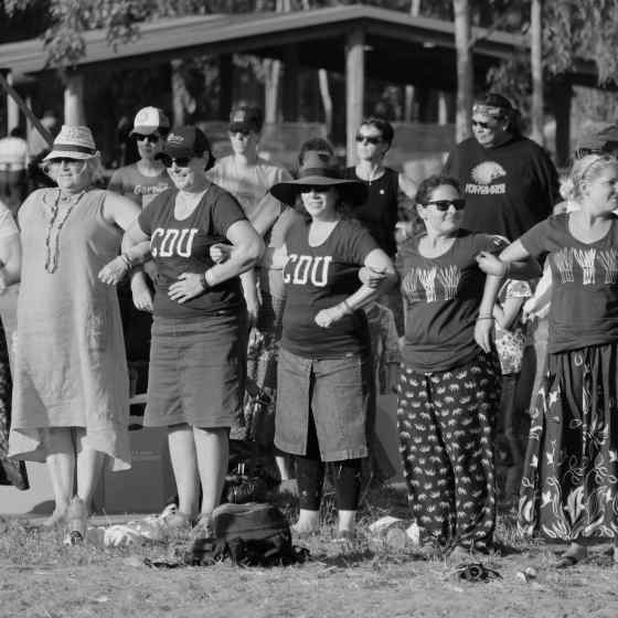 Garma attendees link arms at the bunggul to send a message that they say NO MORE to family violence