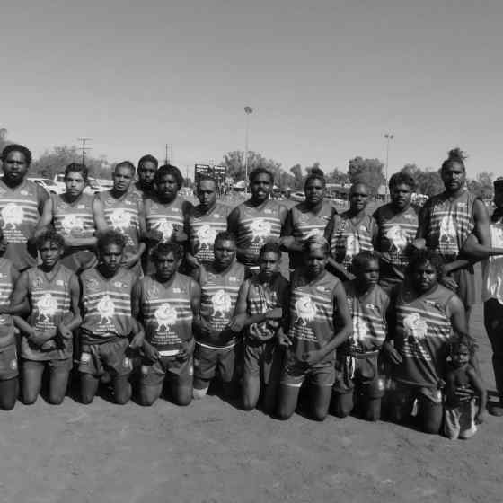 Ti Tree Roosters link arms before the match.